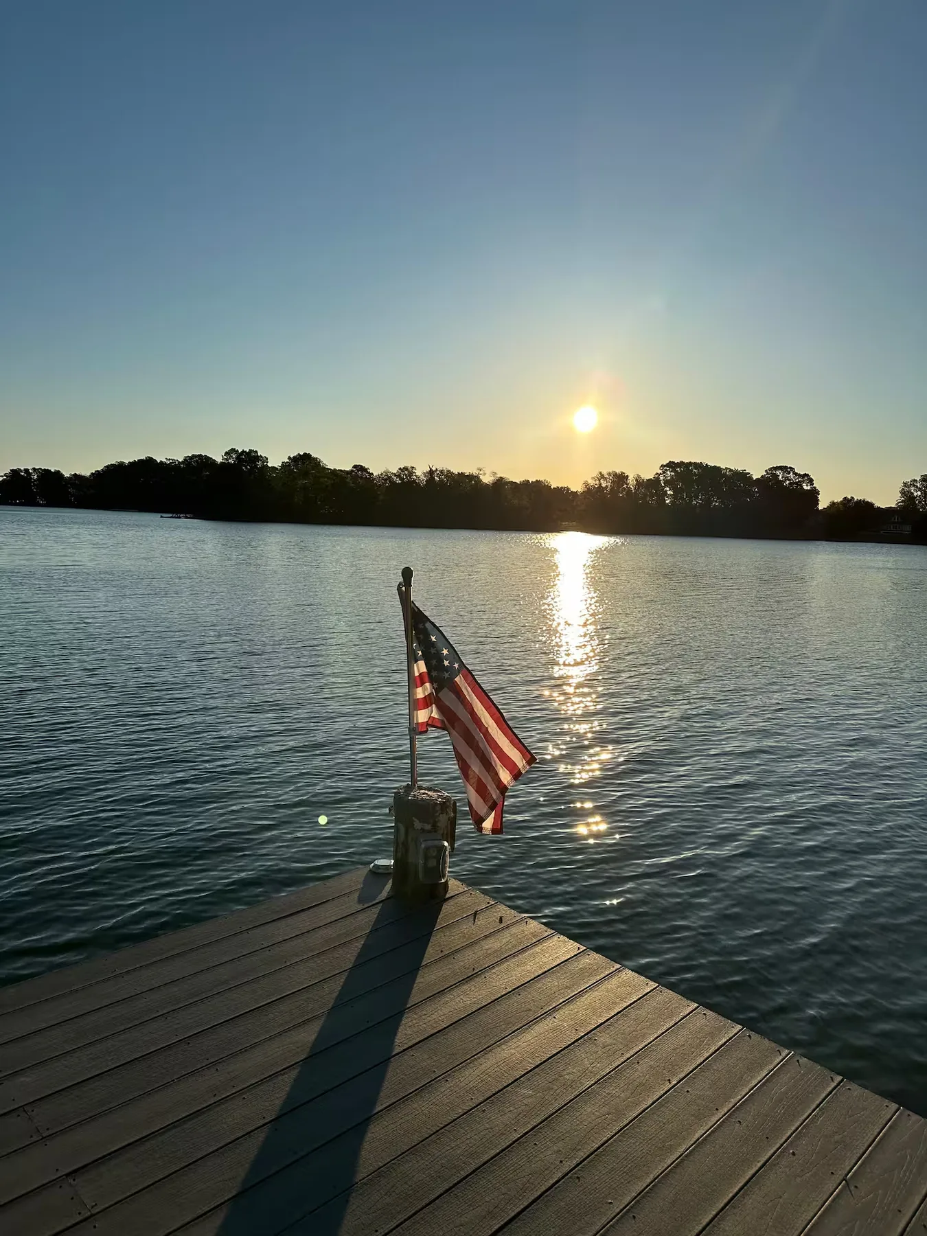 Private dock with American flag at sunrise